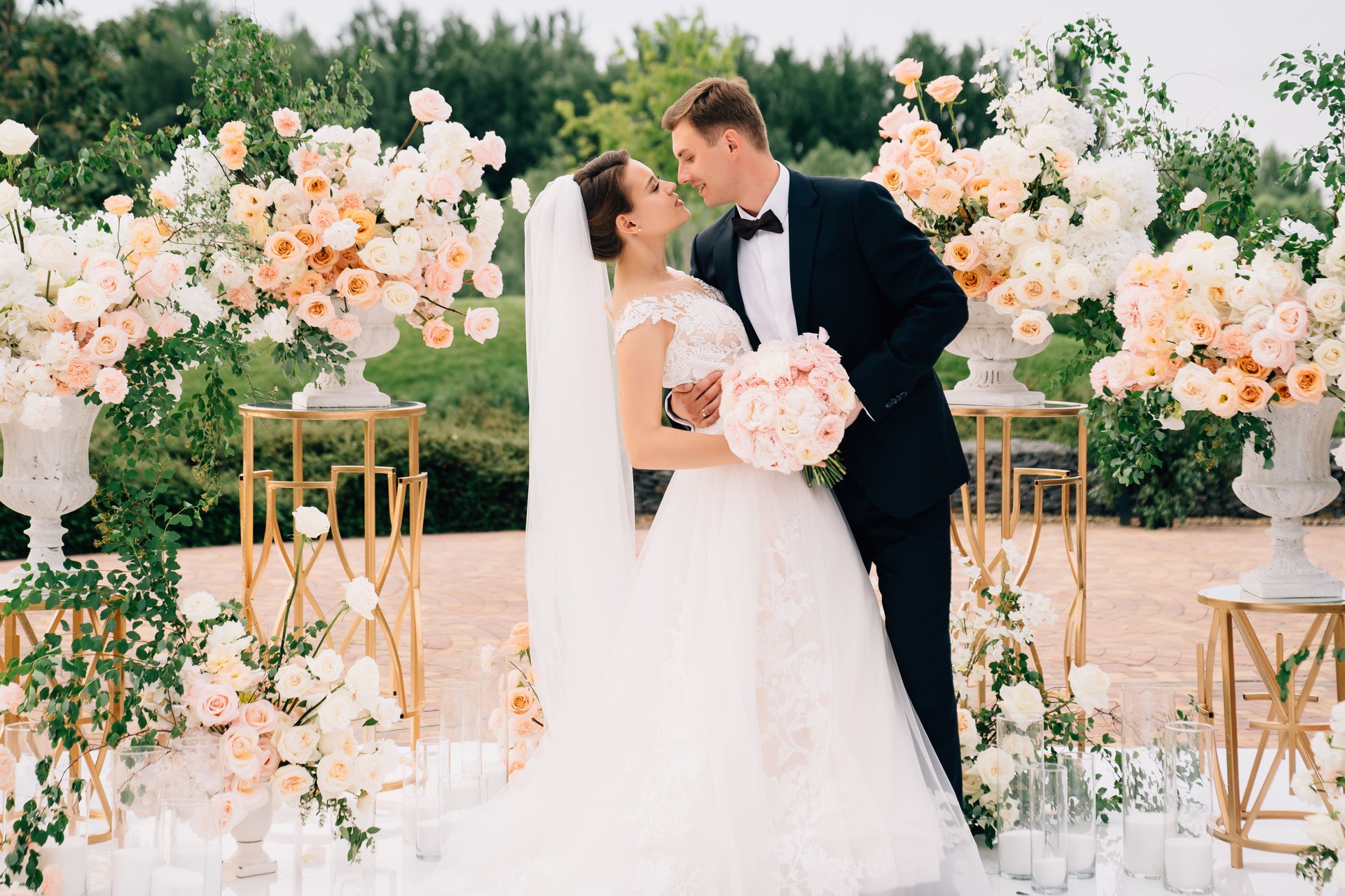 bride and groom in the wedding ceremony area of live white and pink flowers.